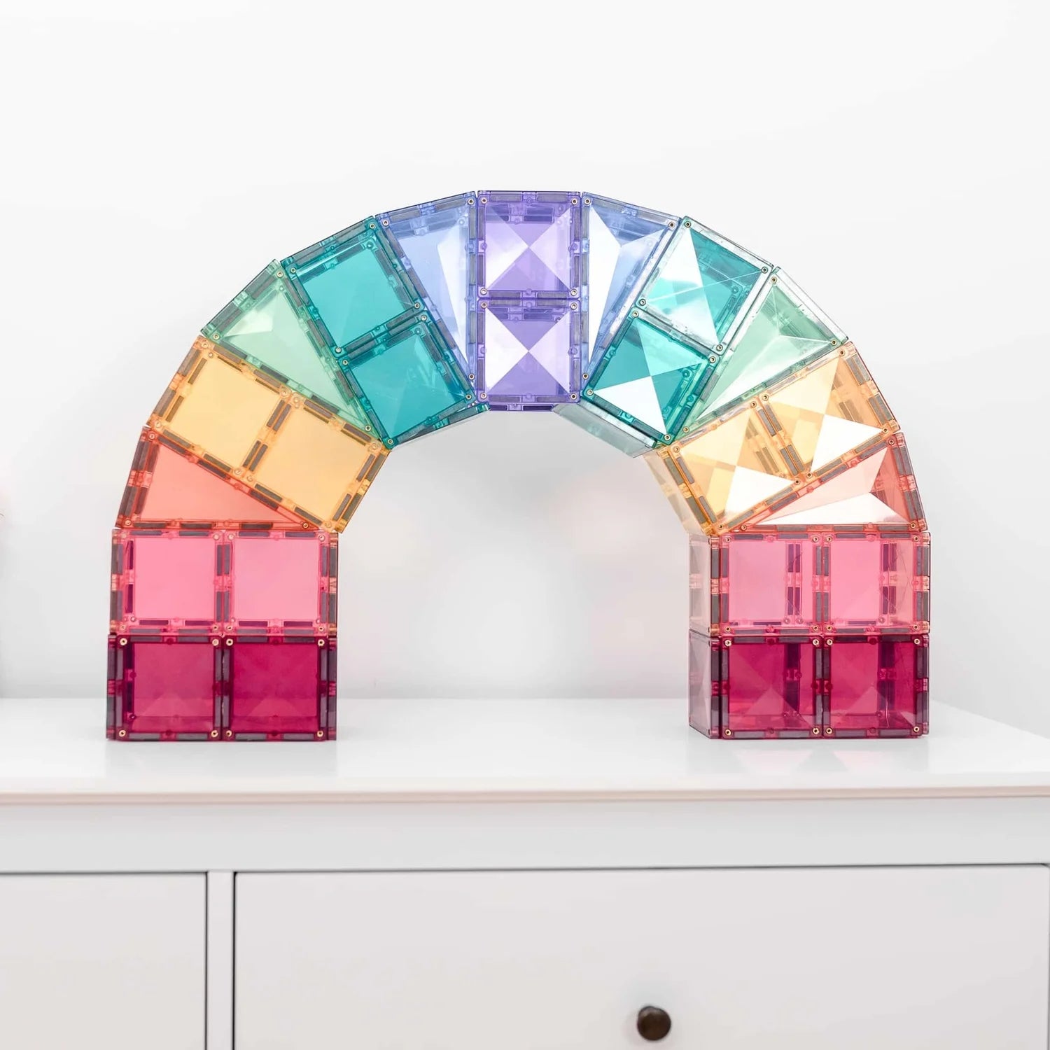 Magnetic tiles forming bridges, castles, and towers.
