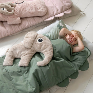 Child snuggled in green quilted slumber bag.