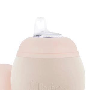 Baby drinking from a flexible silicone training cup.