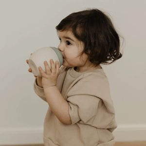 Toddler is drinking water with bubble bottle.