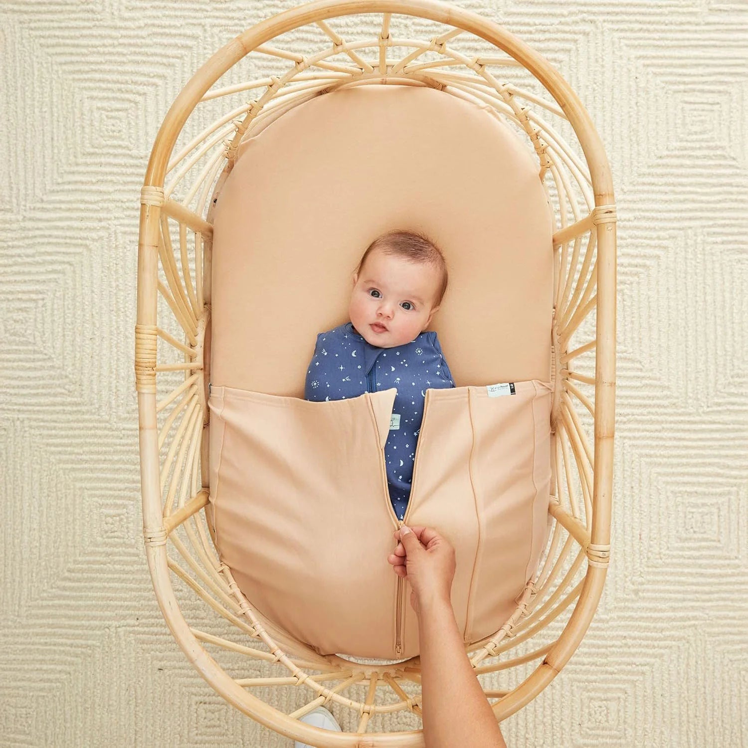 Baby sleeping safely in a crib with a secure Baby Tuck Sheet.