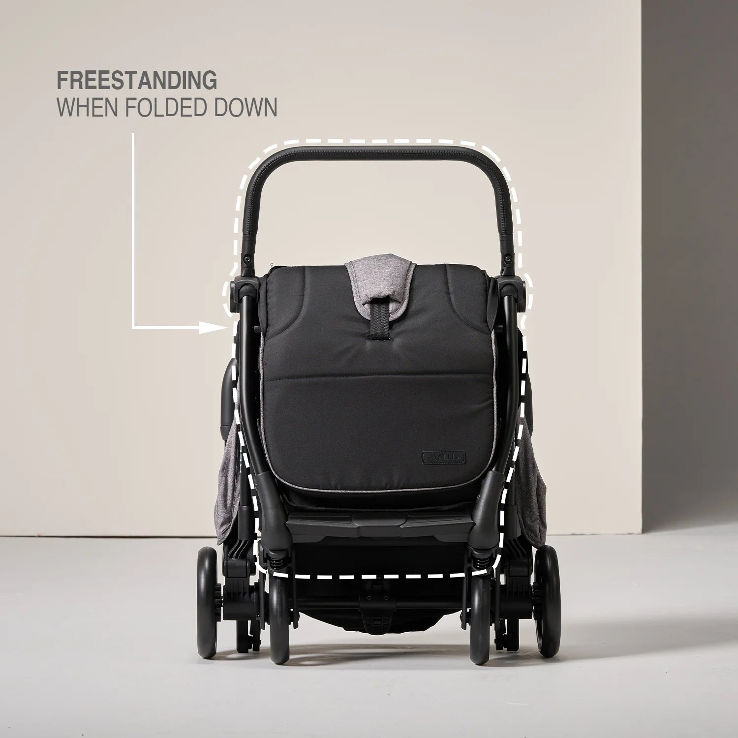 Black stroller folded down on a light gray background