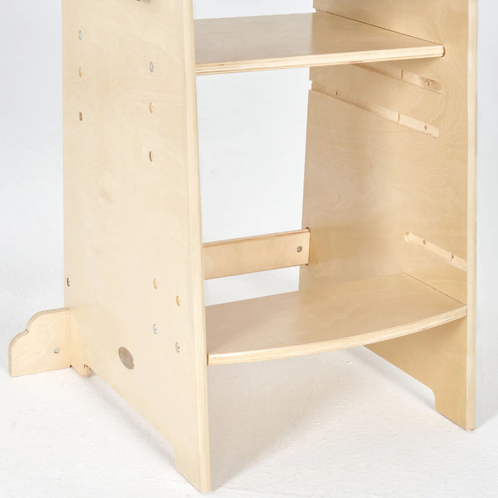 A learning tower with two shelves made of wood with two shelf attached.