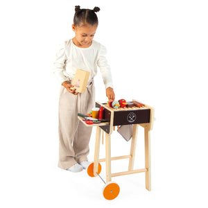 Child arranging food on the barbecue set, enhancing creativity and motor skills.