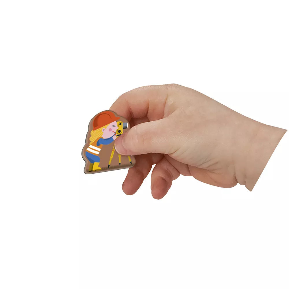 Child’s hand placing a magnetic construction vehicle piece onto Janod Magnetibook play surface