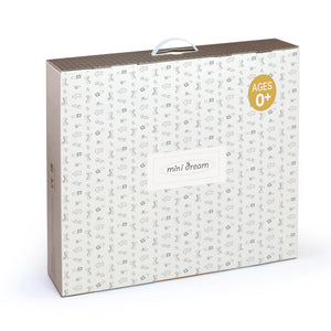 A rectangular product box with a white patterned front, brown side panels, a top handle, and a gold circular badge reading 'AGES 0+'. The front has a label that says 'mini dream'.