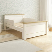 White and wood children's bed in a room with light-colored walls and flooring.