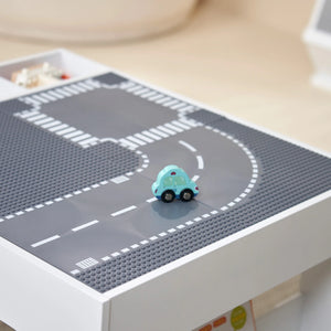 A toy car is parked on a kids activity table.