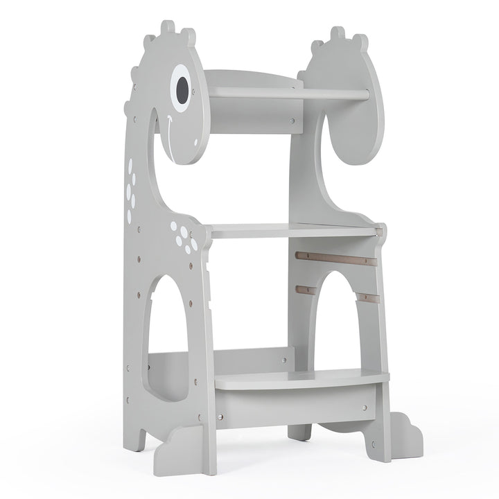 A gray Kitchen Helper Tower shaped like a baby dino with a black and white patterned.