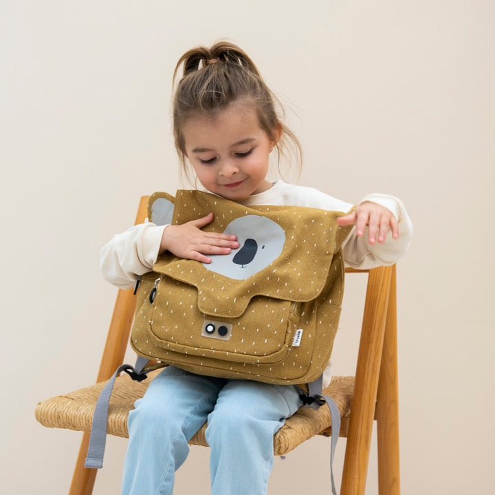 Closeup of a child's hands using the easy-open zipper on the front pocket of an animal satchel backpack.