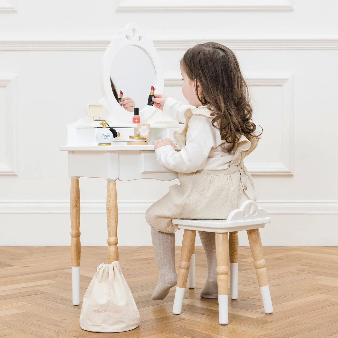 A girl is playing with the Le Toy Van vanity table & wooden stool.