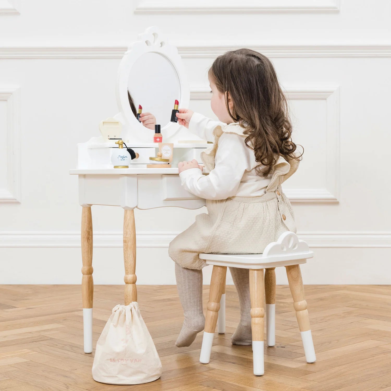 A girl is playing with the Le Toy Van vanity table & wooden stool.