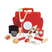 Red toy first aid kit with various medical tools on a white background