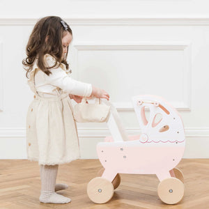 A girl is playing with the doll pram toy