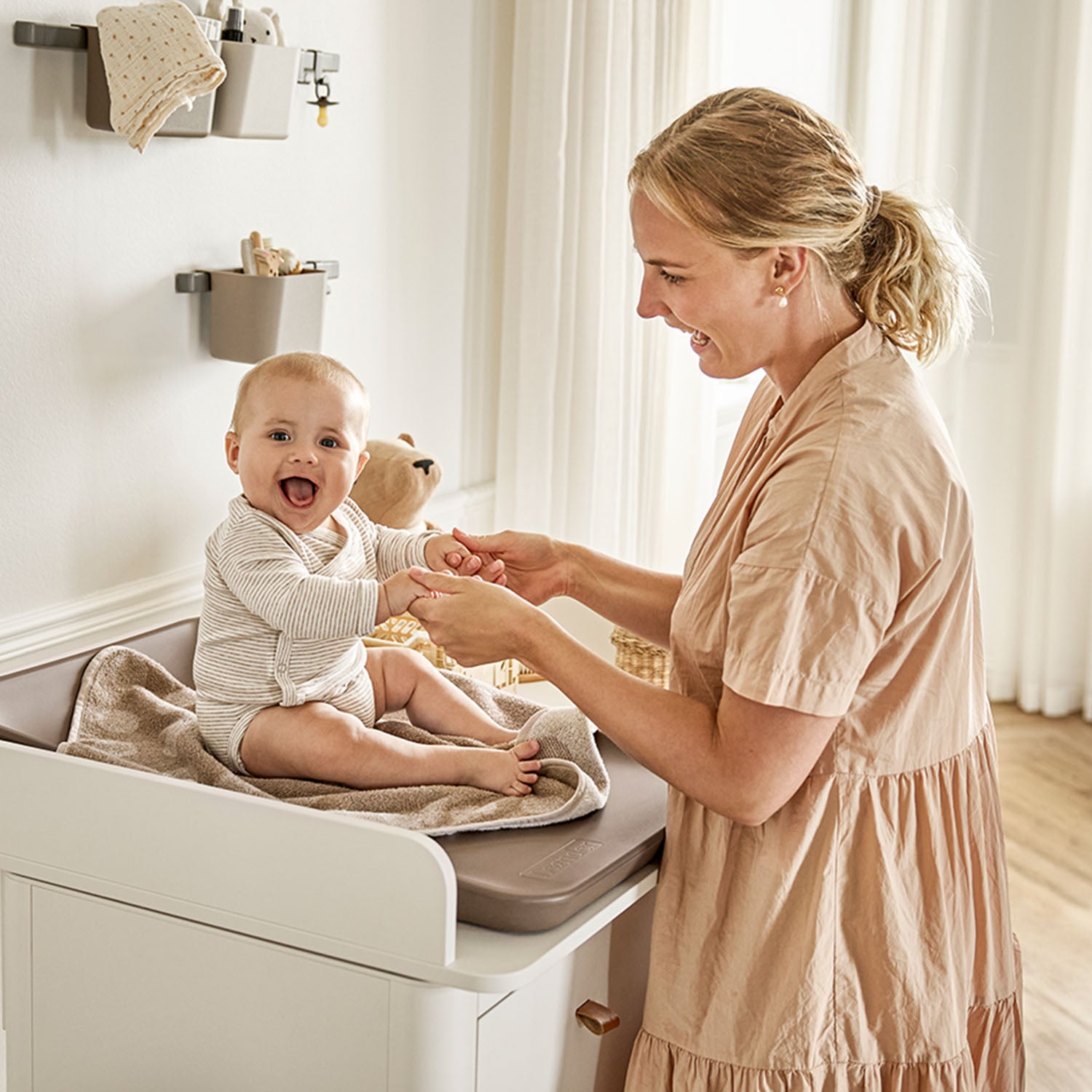Matching changing unit securely attached on top of the dresser.