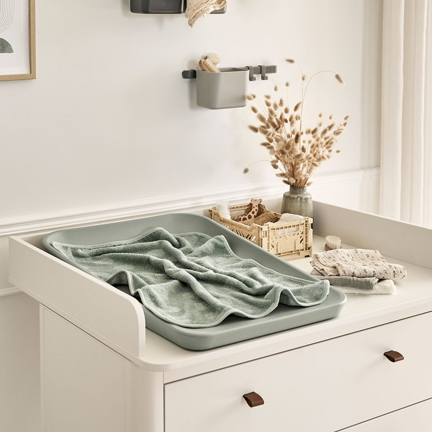 Dresser transformed into a safe baby changing station with raised sides.