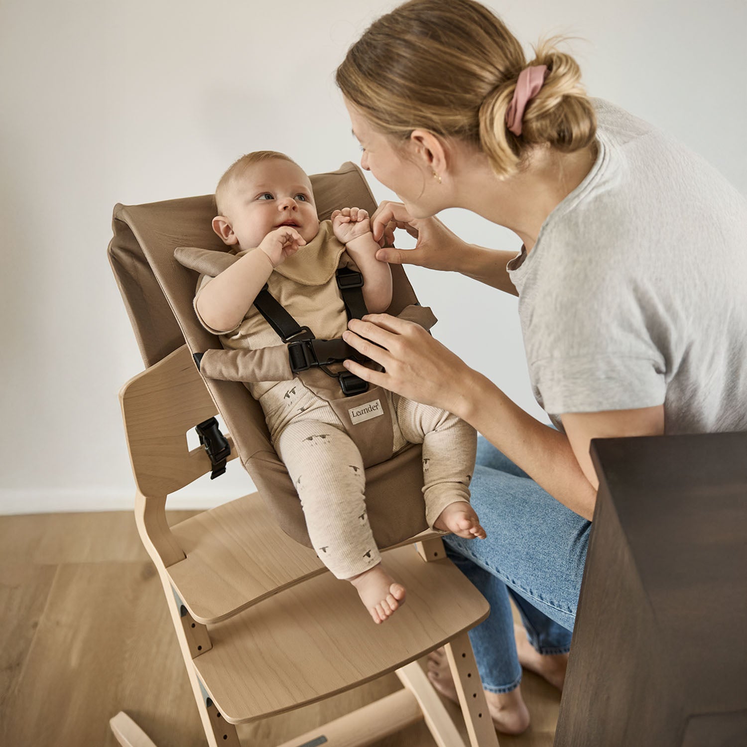 A Leander Louie highchair equipped with the Newborn Seat and 5-point harness, allowing a baby to join the family at the table from birth.