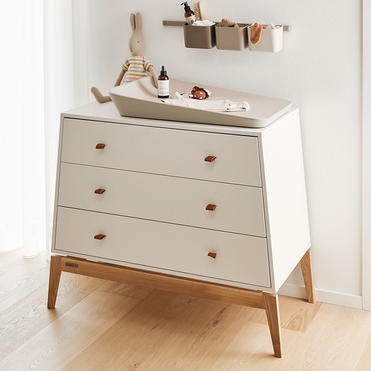 Changing area set up with a baby mat, diapers, and wipes on the dresser.