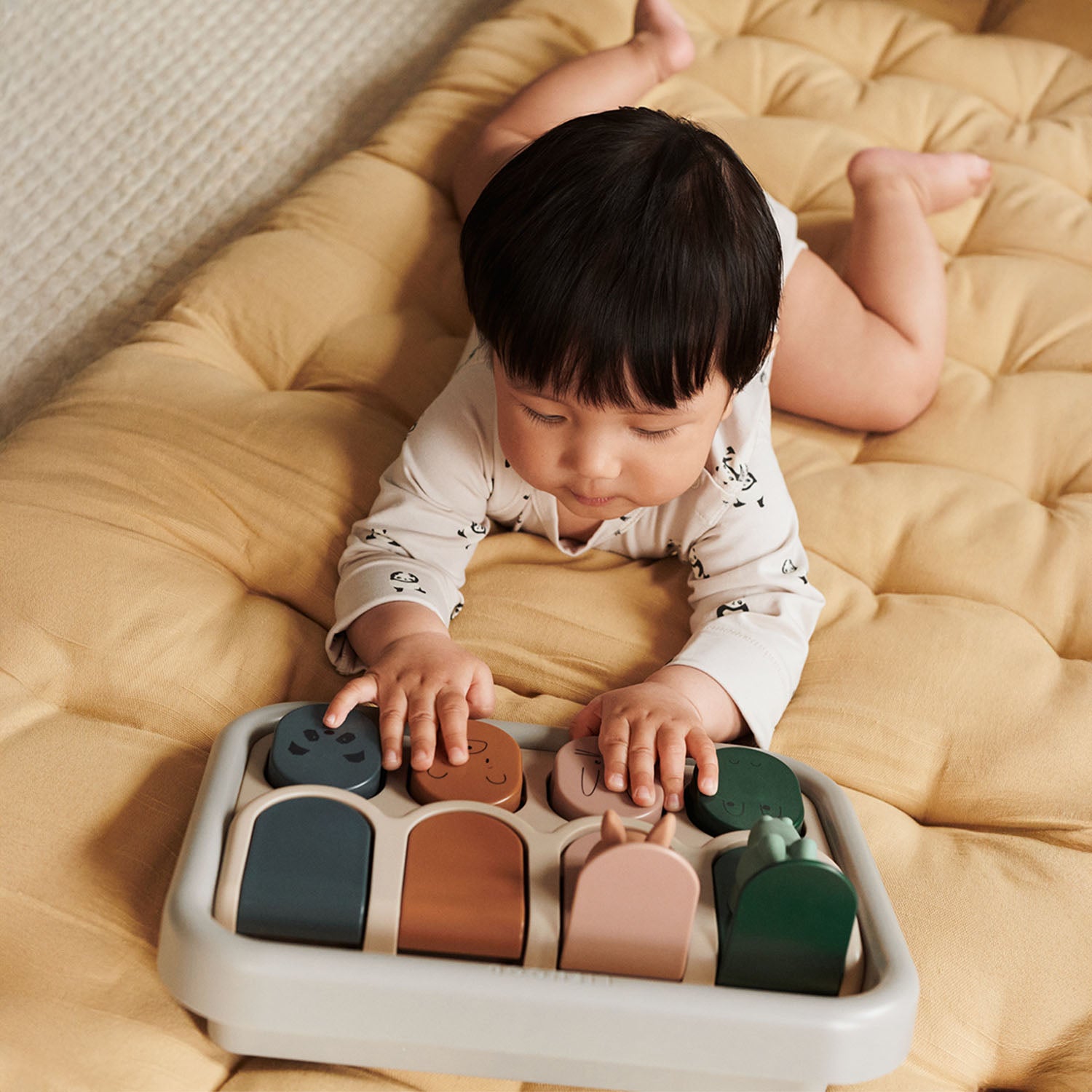 Baby pressing a button to make animals pop.