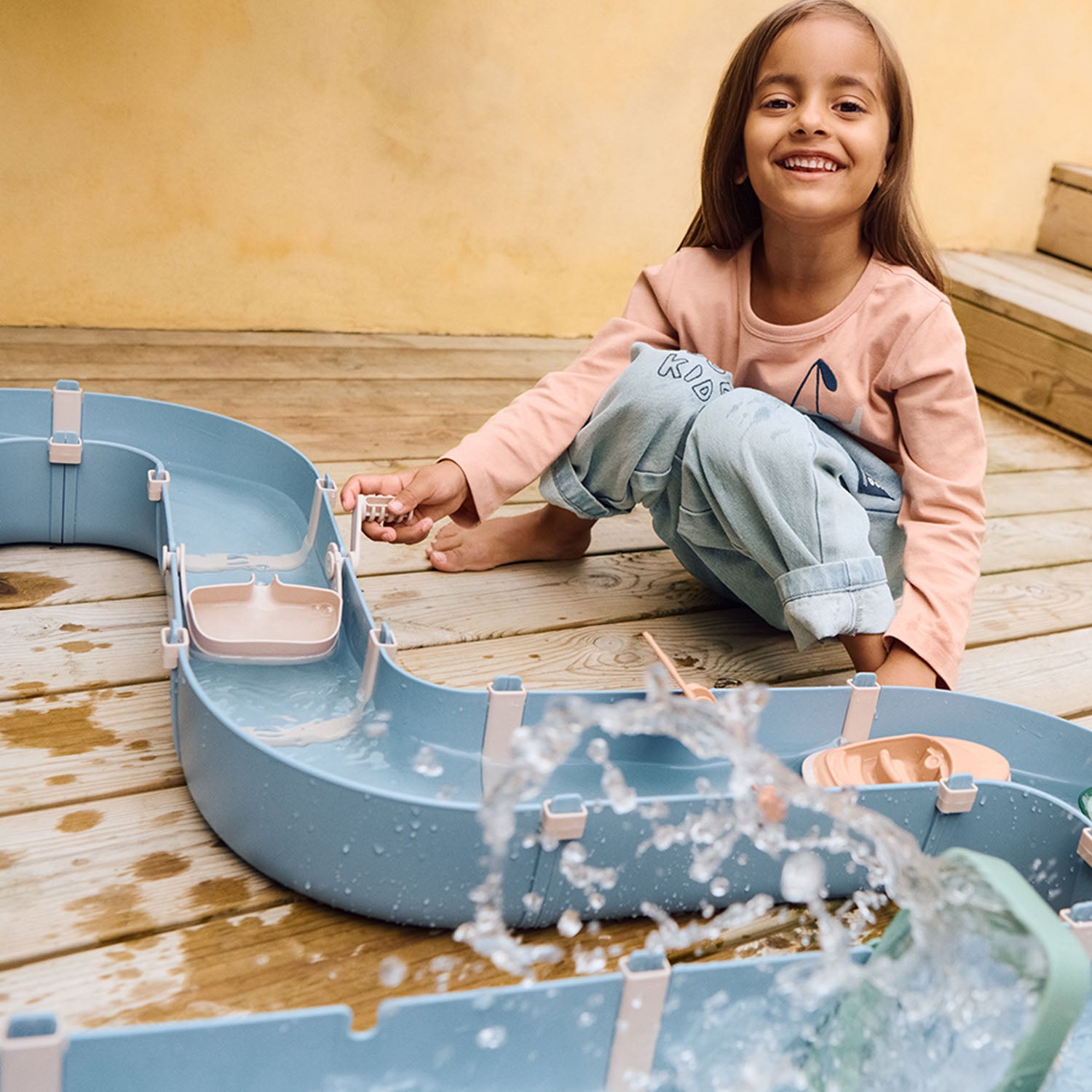 Kids building water canals with boats and water wheel