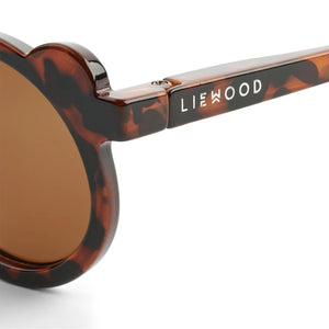 Detail shot of the subtle silver Liewood logo on the temple of Darla Mr. Bear sunglasses.