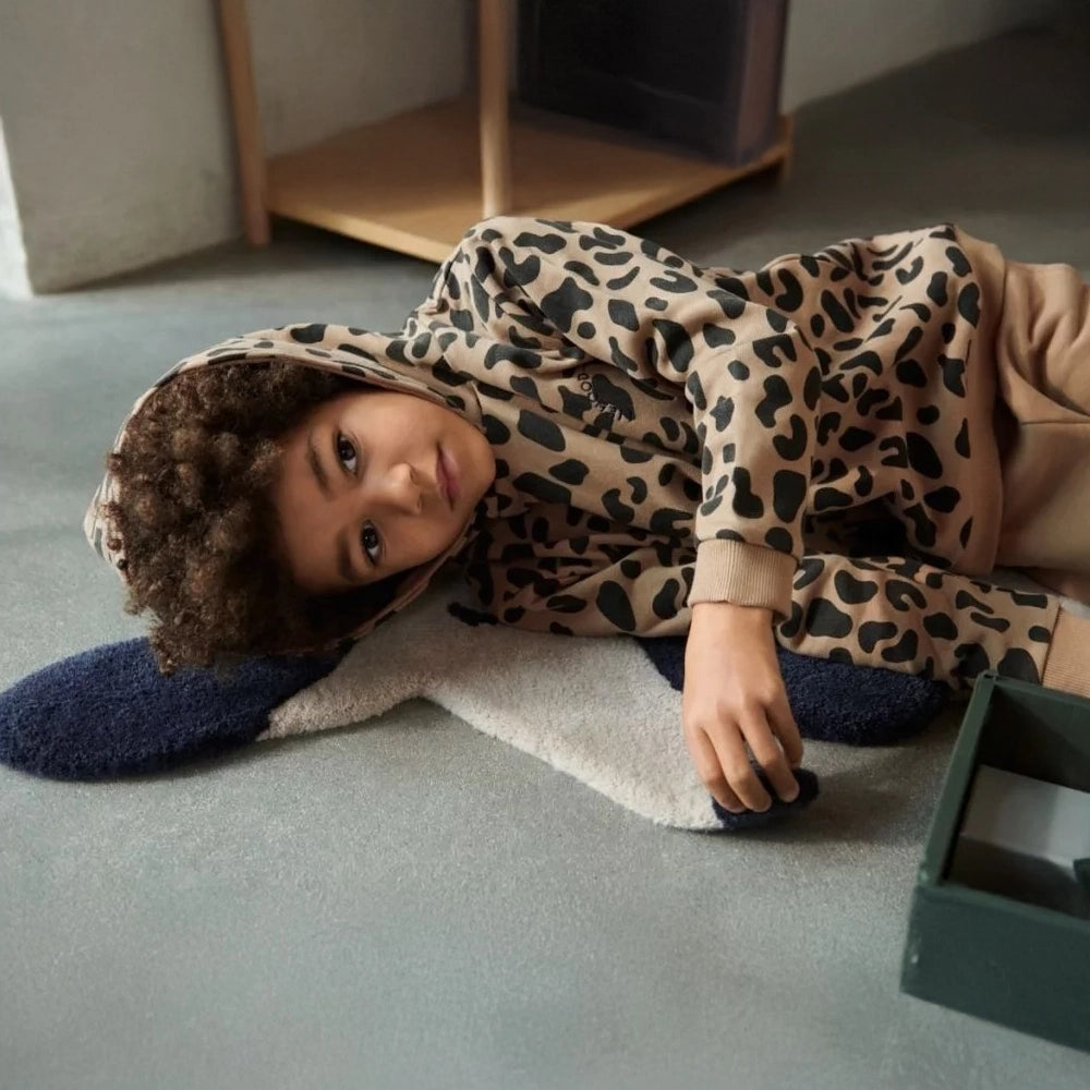 Child wearing the hoodie while lounging and having fun.