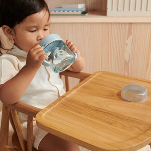 A toddler is drinking water with kylo tritan sippy cup.