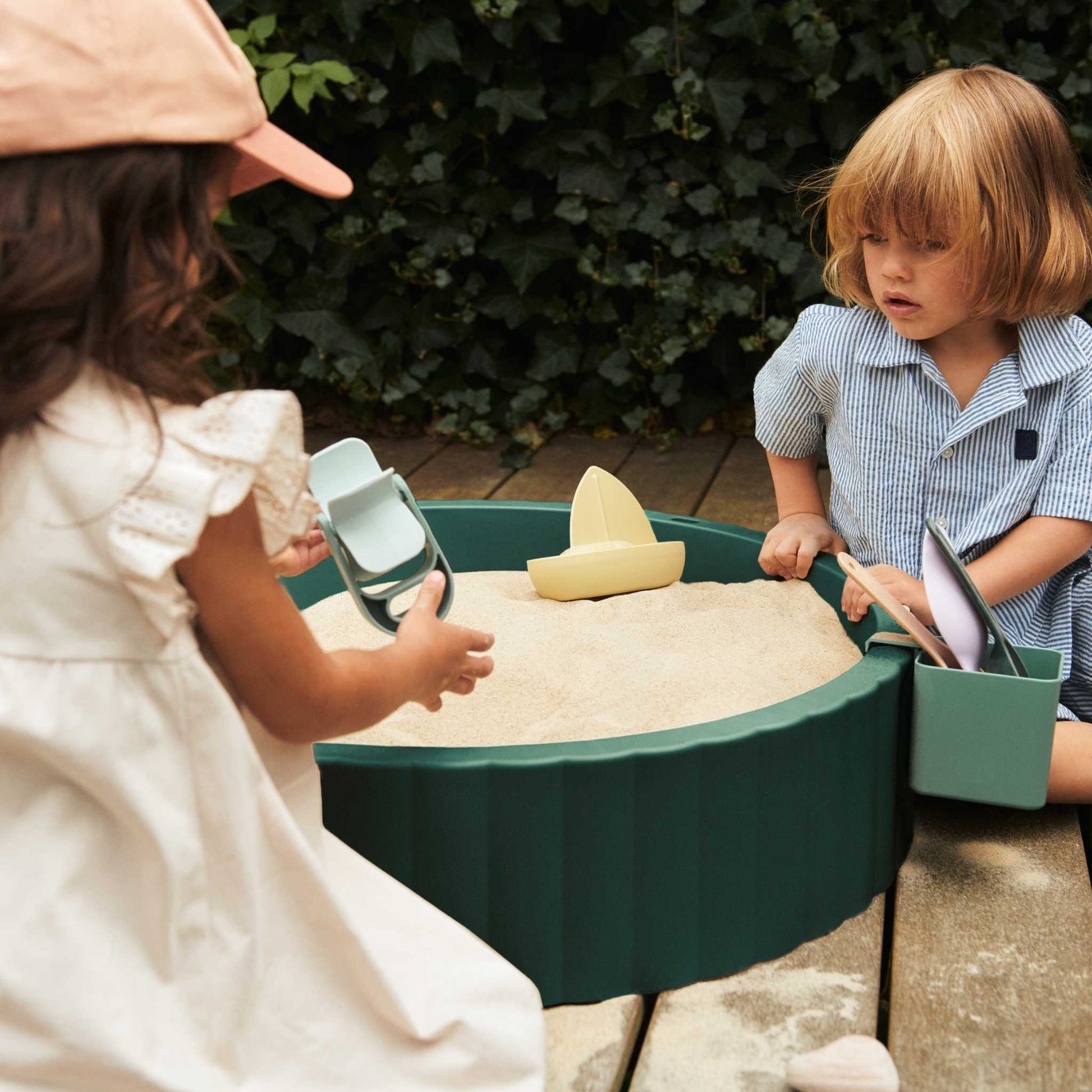 Children digging and building in the sandpit.