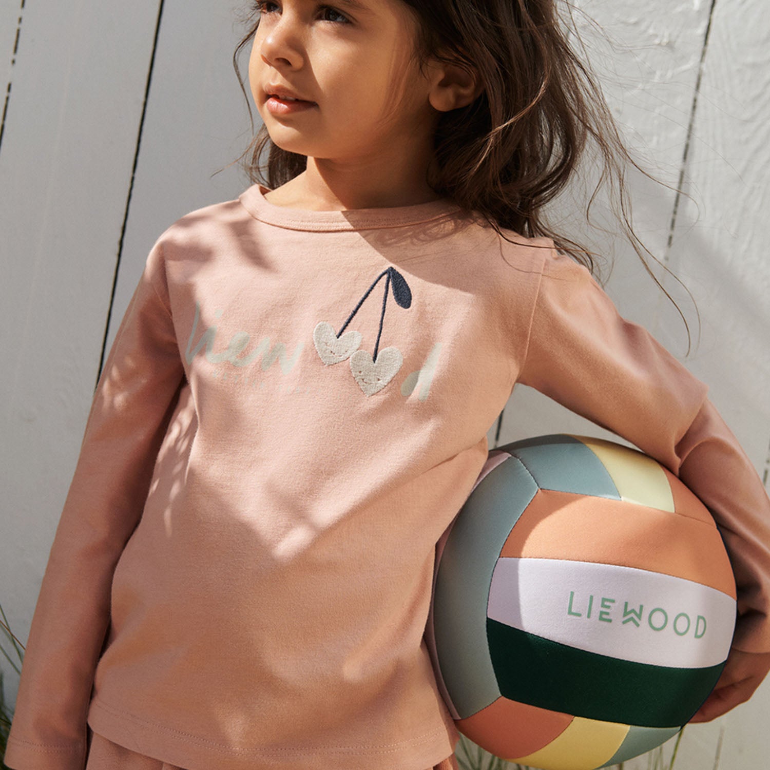 Children playing with Liewood Villa Peppermint volleyball in garden.