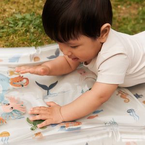 Baby reaching and pressing the water-filled center