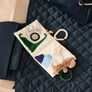 Liewood Fey soft book styled alongside a matching quilted baby bag and travel accessories.