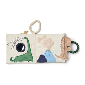 Inner page of soft book showing green dinosaur design, attached silicone teether, and sensory fabric.