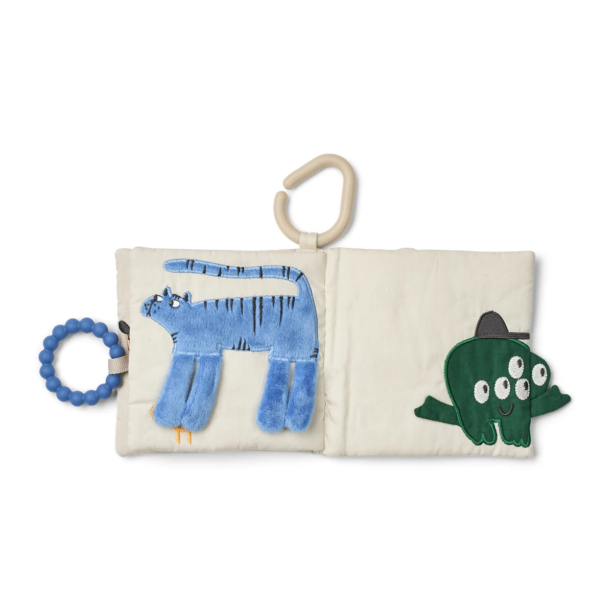 Soft book page with illustrated trousers design, green fabric shape, and blue teething loop