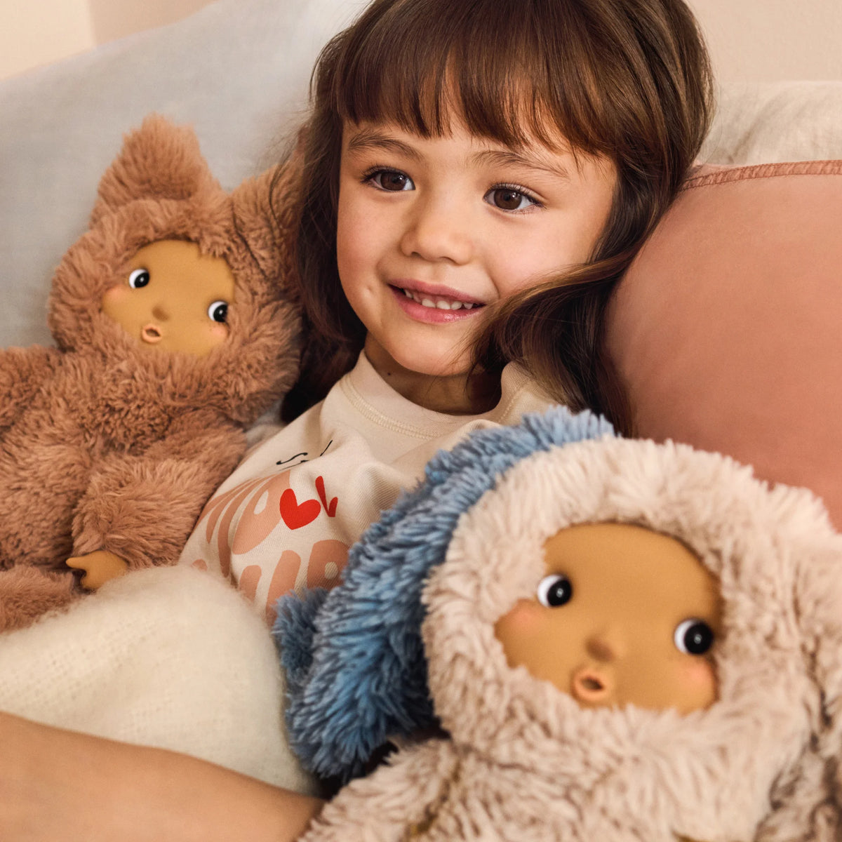 A girl is playing with Liewood Misa Cleo plush doll in Pale Tuscany, cosy bedroom setting