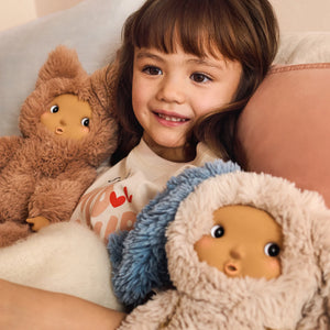 A girl is playing with Liewood Misa Cleo plush doll in Pale Tuscany, cosy bedroom setting