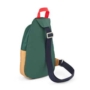 Back angle view of a Liewood colorblock one shoulder school bag in dark green, navy blue, and ochre with an adjustable strap
