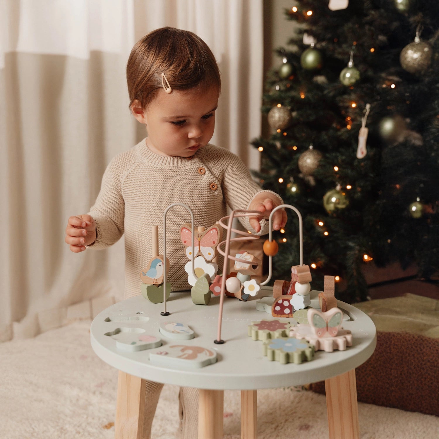 Toddler playing with beads on the little dutch activity table.