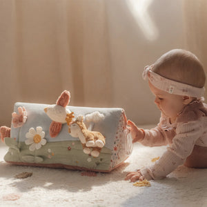 A baby is playing with Little Dutch activity triangle