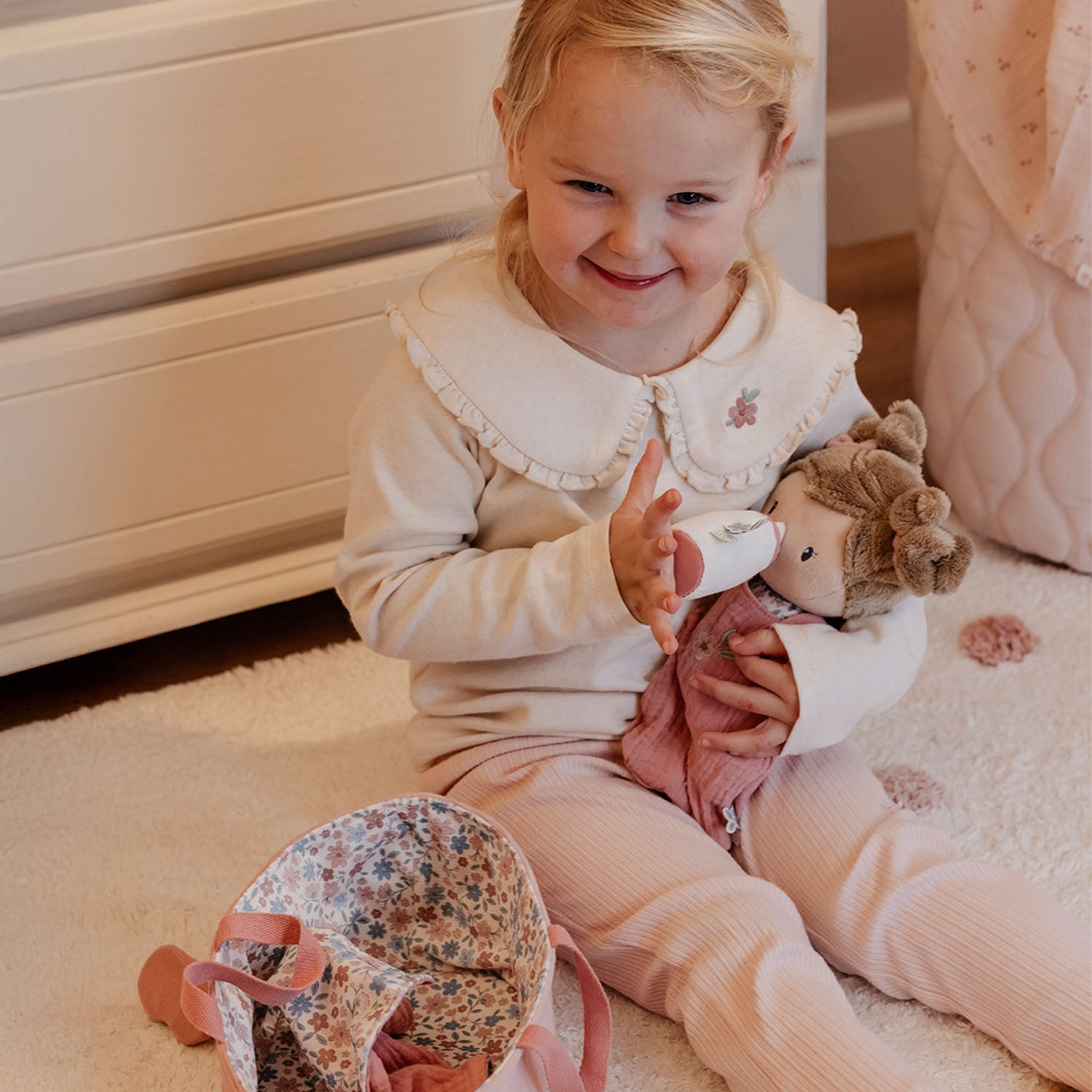 Toddler holding Little Dutch Baby Doll Rosa.