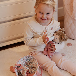 Toddler holding Little Dutch Baby Doll Rosa.