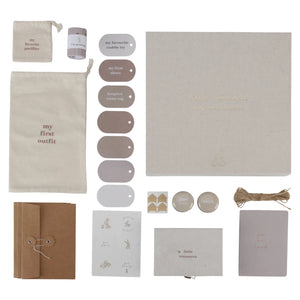Flat-lay of the memory box contents: booklet, tags, envelopes, and keepsake tins.