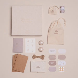 Flat-lay of the memory box contents: booklet, tags, envelopes, and keepsake tins.