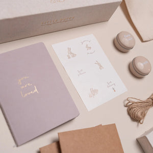 Close-up of tin boxes labeled "First Hair" and "First Teeth" inside the memory box.