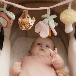 A baby is playing with the little dutch car seat toy chain.