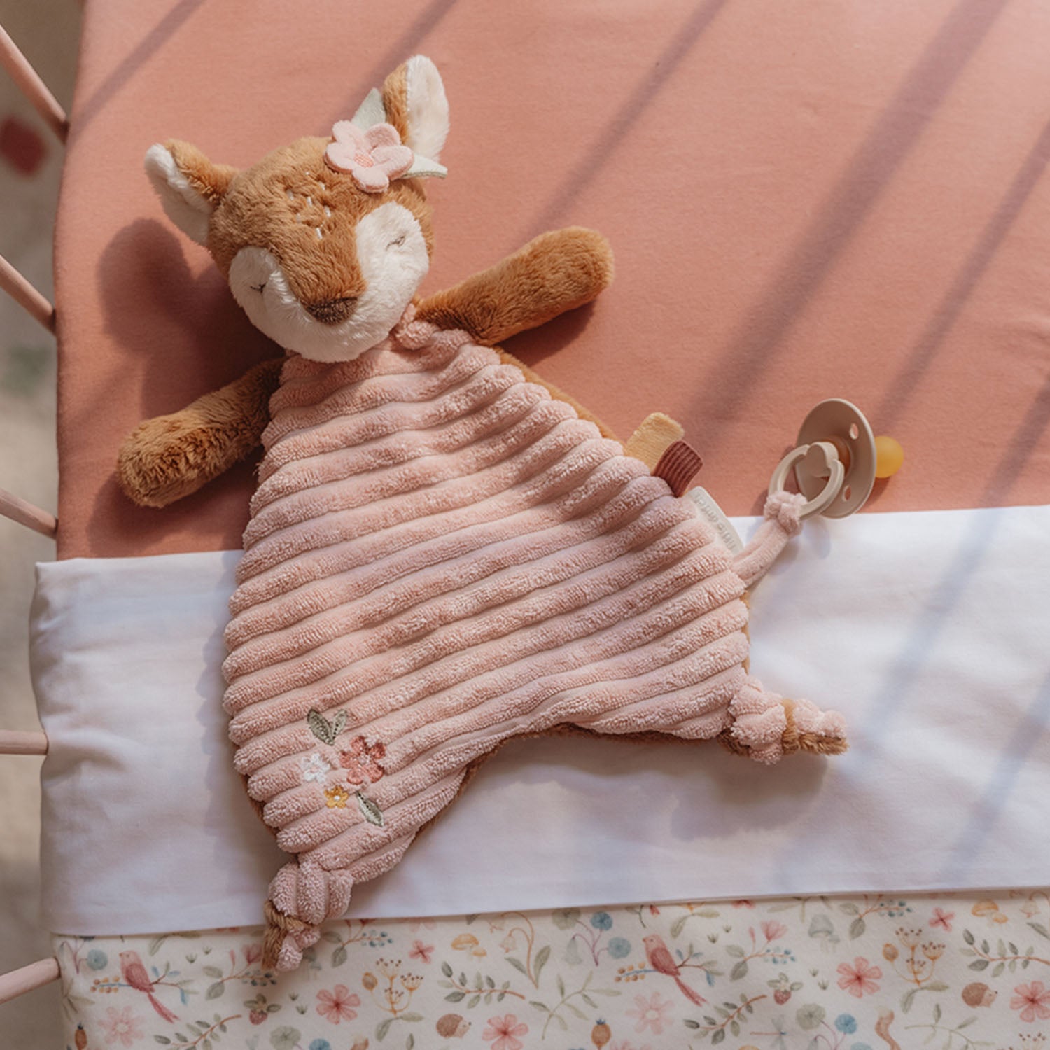 Little Dutch Cuddle Cloth Deer Fairy Garden lying on a baby’s crib.