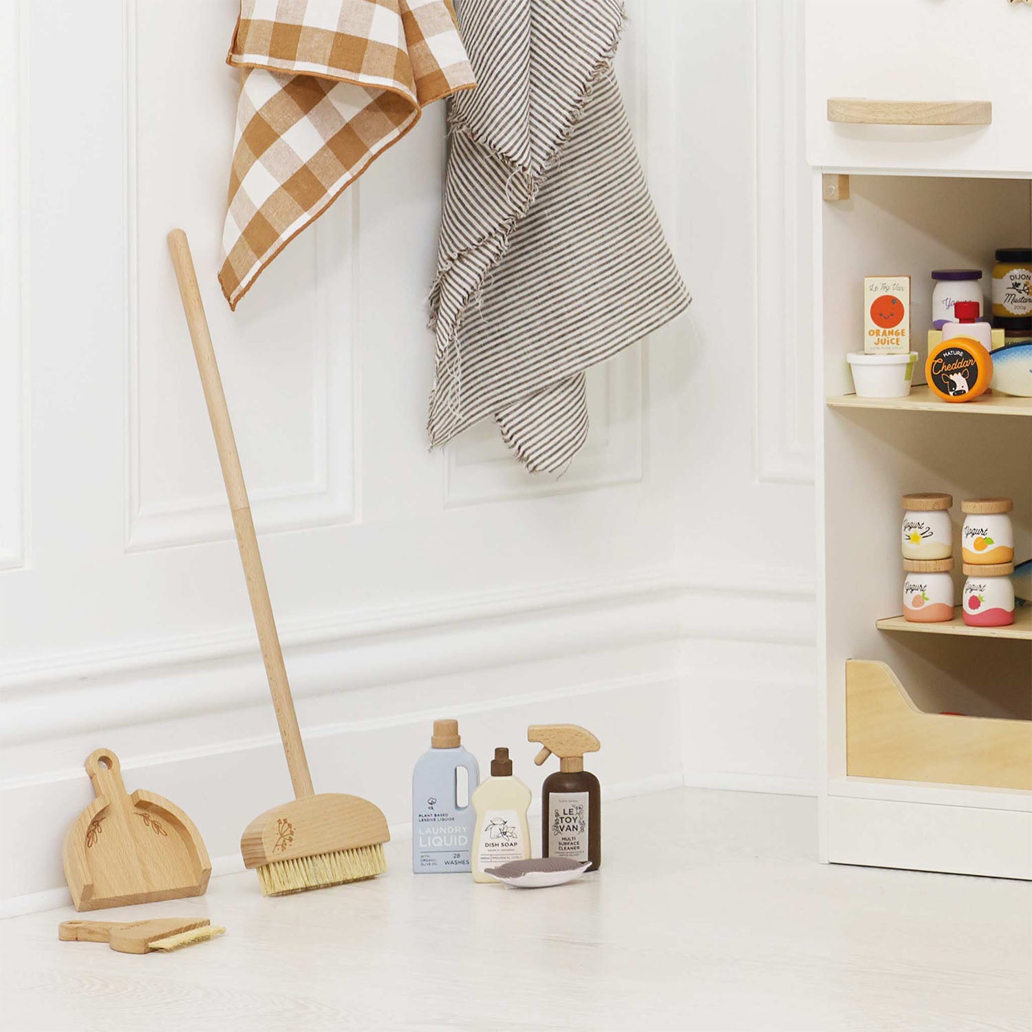 Wooden toy cleaning set with broom, brush, and dustpan for kids.