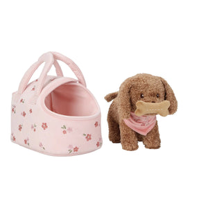 Small pink pet carrier with floral pattern and a brown dog toy holding a bone on a white background