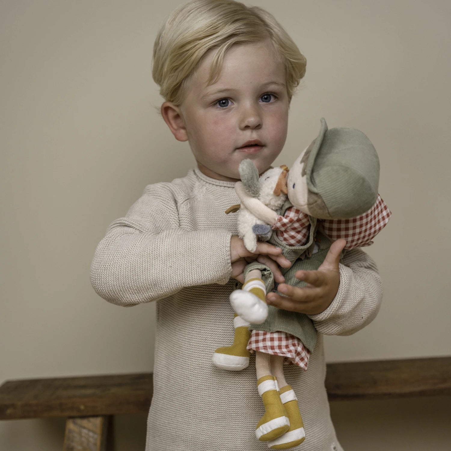 Toddler hugging Farmer Rosa and Jim doll with her sheep and chicken.