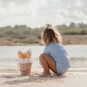 Child playing with Little Dutchpink ice cream bucket set in the sandbox.