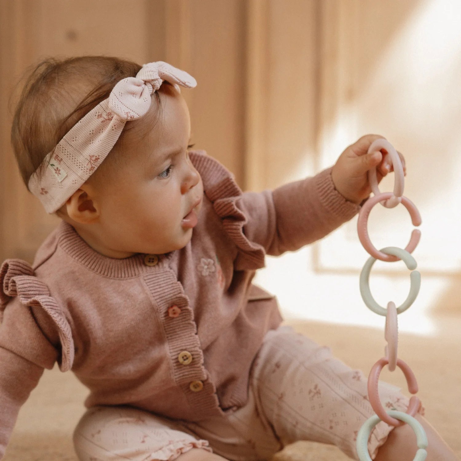 Baby playing with loops on a play mat.